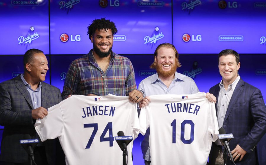 Los Angeles Dodgers closer Kenley Jansen and third baseman Justin Turner pose for photos with manager Dave Roberts, left, and Andrew Friedman, president of baseball operations, right, following a news conference Wednesday, Jan. 11, 2017, in Los Angeles. The two re-signed with the team as free agents. (AP Photo/Jae C. Hong)